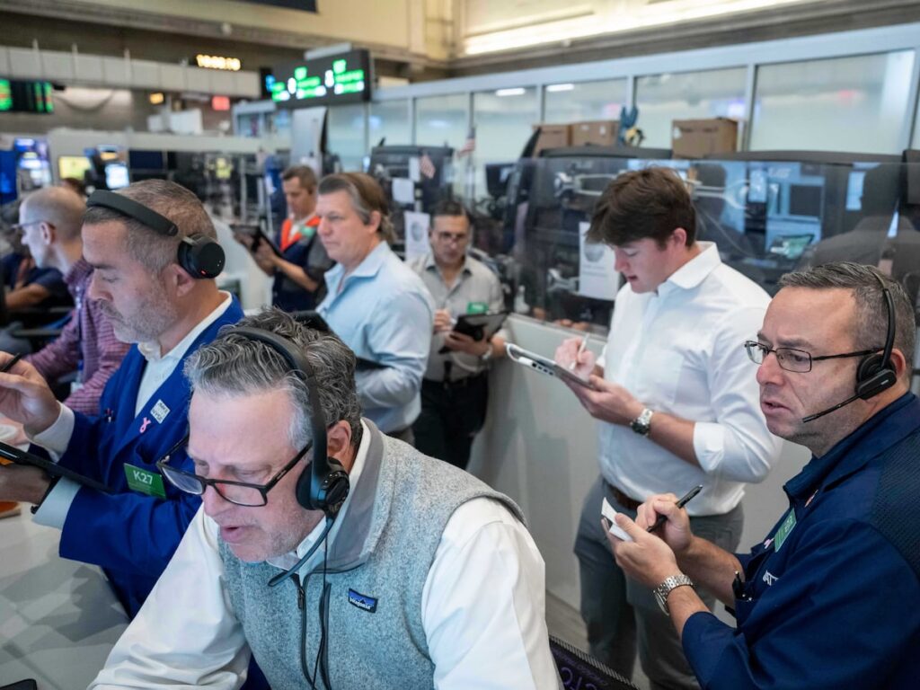 US stocks hover near their latest record in mixed trading on Wall Street